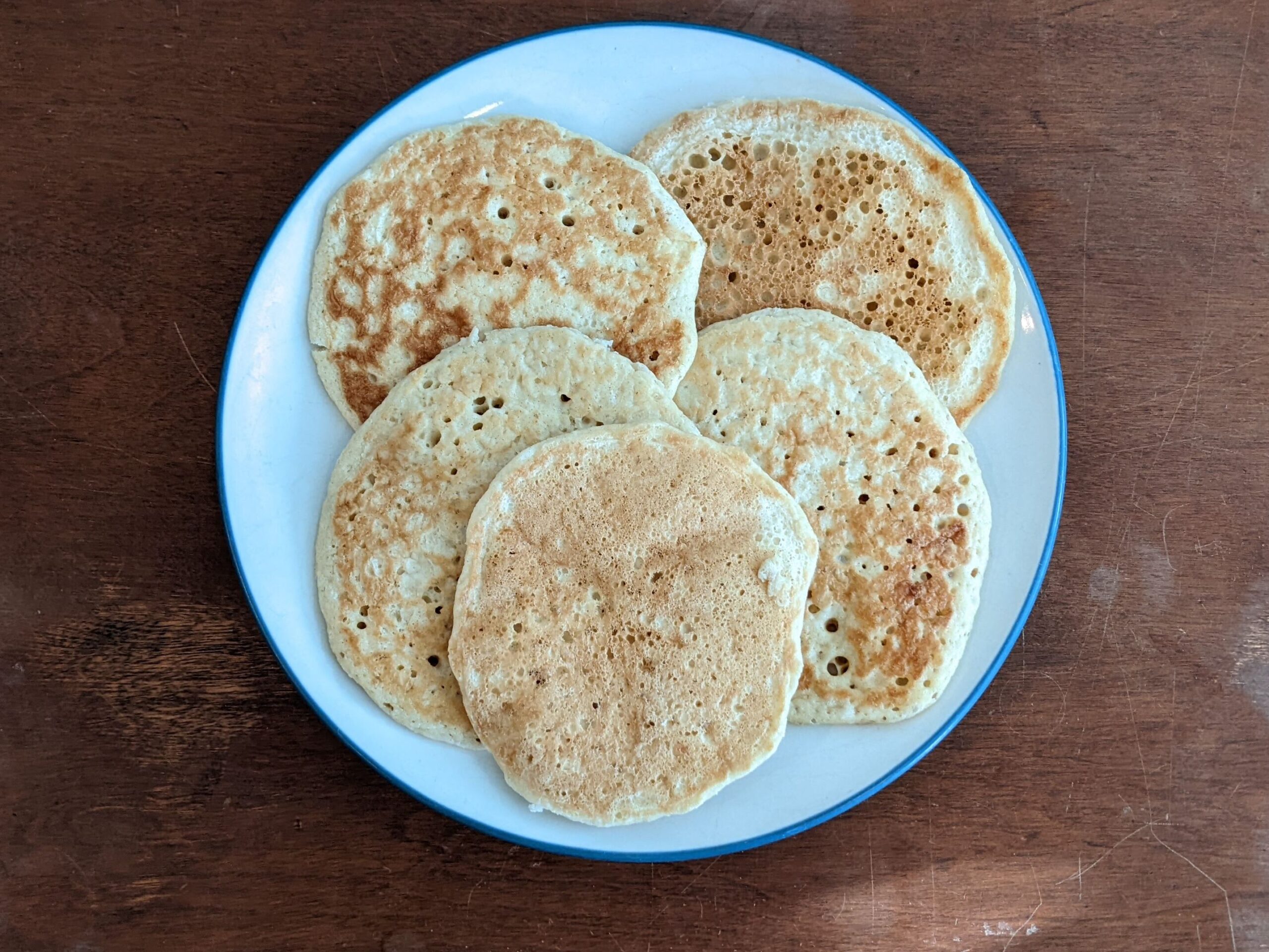 sourdough pancakes on a plate sitting on top of a farmhouse table