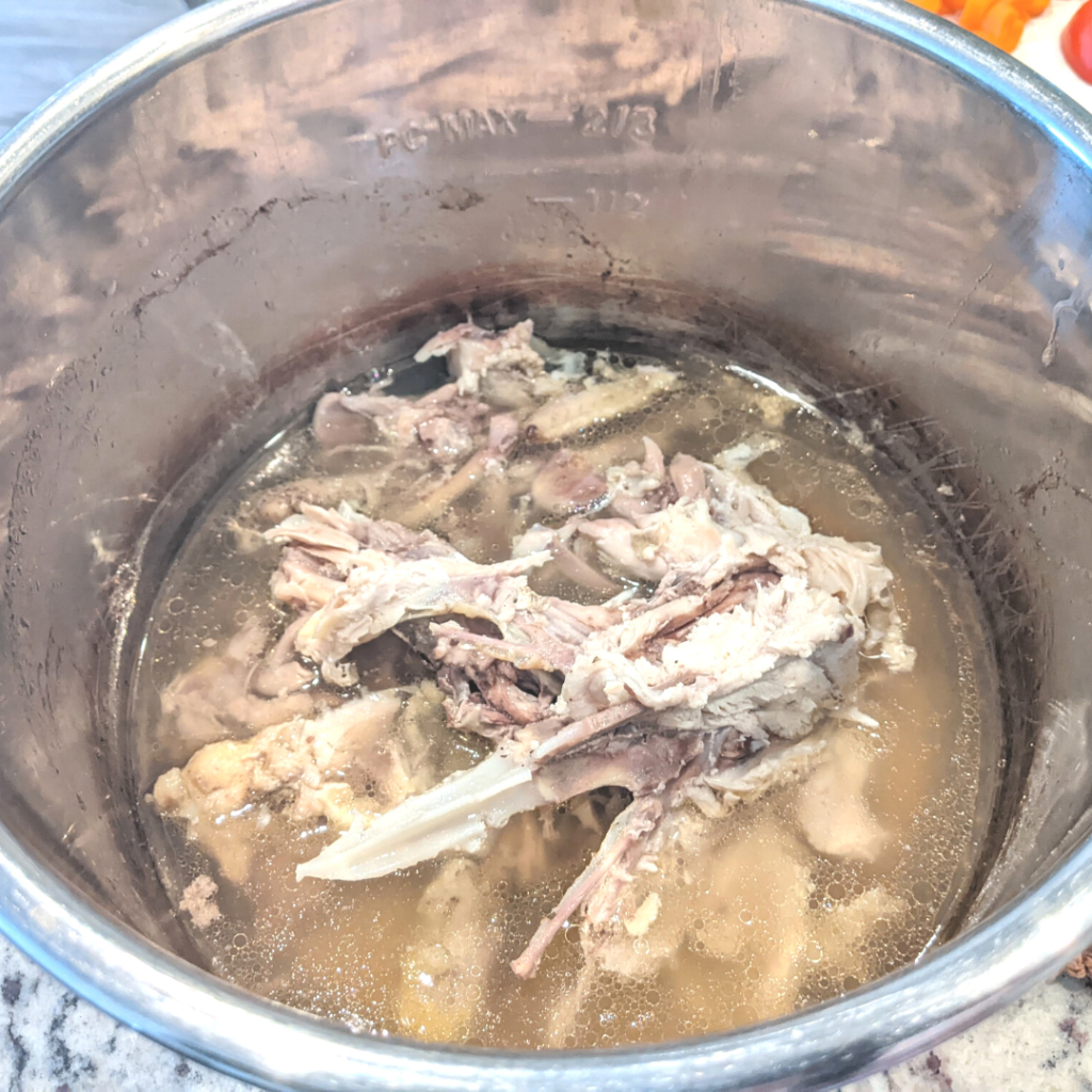 chicken bones in water inside an instant pot for making bone broth