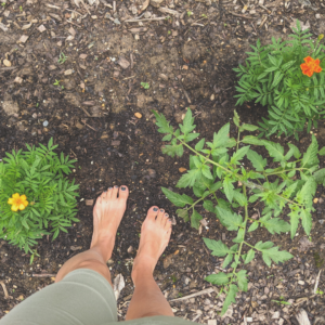 A woman standing barefoot in her therapy garden