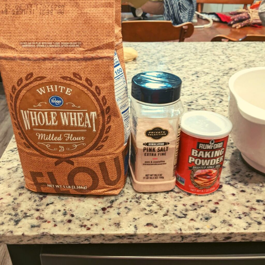 whole wheat flour, pink salt, baking powder and a bowl on a counter. dry ingredients for pancakes