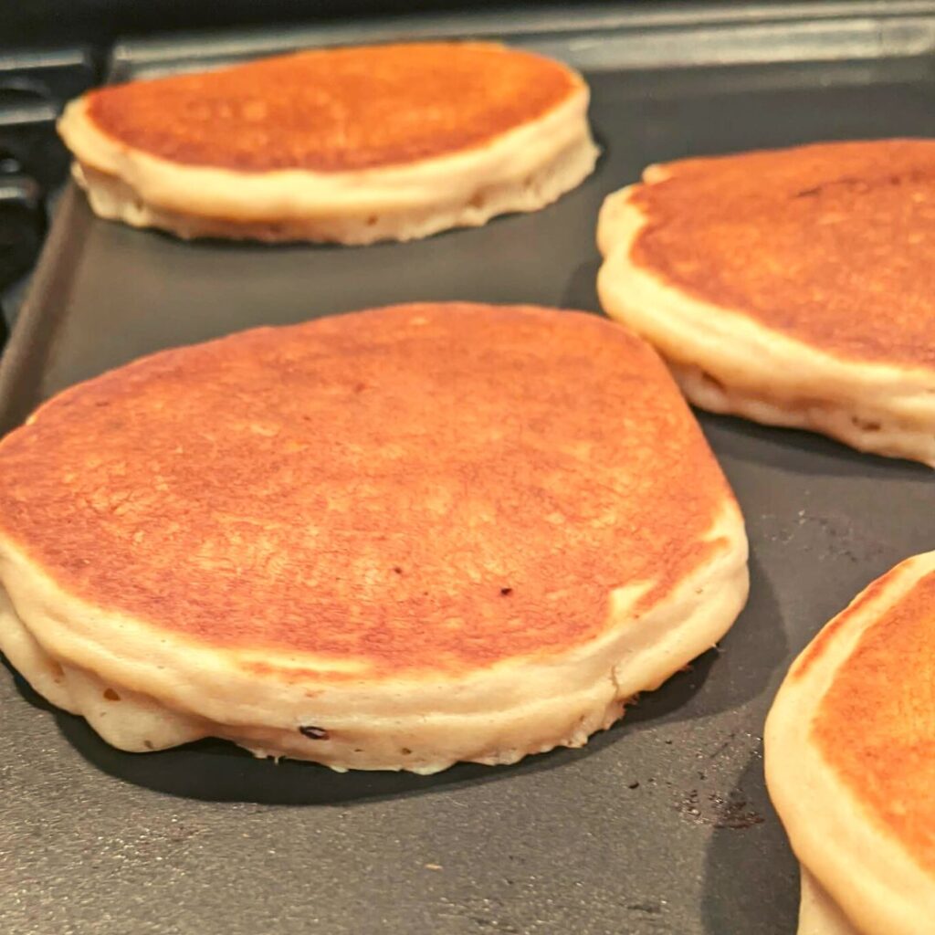 golden whole wheat pancakes on a griddle