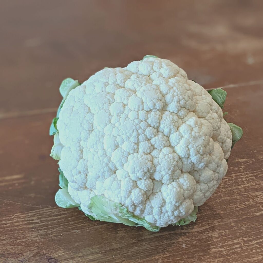 cauliflower head that is sitting on a farmhouse table about to be dehydrated